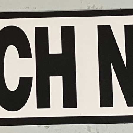 a two inch by eight inch, black-and-white, vinyl sticker with a black border, that says "PUNCH NAZIS"